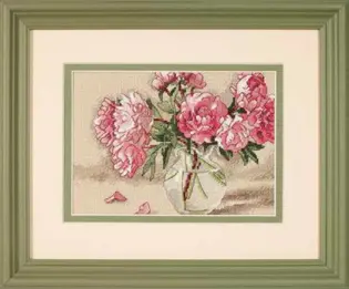 Готова вишита картина за набором Dimensions 65048 "Peonies in Vase" (Півонії у вазі). Ніжні рожеві півонії у прозорій скляній вазі з опалими пелюстками на столі, вишиті технікою лічильного хреста та напівхреста на дрібній канві Aida 18 кольору слонової кістки