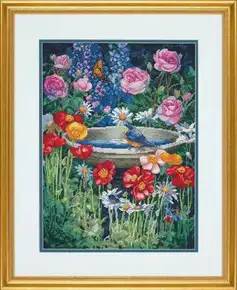 Готова вишита картина хрестиком за набором Dimensions 70-35288 "Garden Reflections" (Чарівний сад). Яскравий квітковий сюжет із кам’яною чашею для птахів, синьою пташкою на краю, золотавим метеликом, рожевими трояндами, червоними маками та блакитними дельфініумами. Робота виконана технікою лічильного хреста на темно-синій канві Aida 16