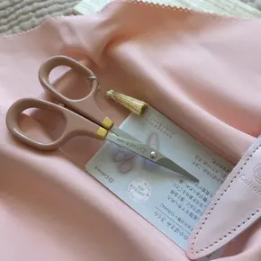 Крупний план лакованих ручок японських ножиць Cohana Sakura. Видно унікальну текстуру рожевого лаку та витончений золотий розпис макі-е (maki-e). Ексклюзивна фурнітура для преміального рукоділля